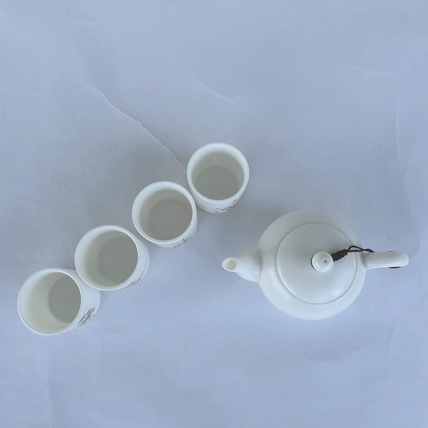 Ceramic white coffee cups and teapot